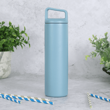 Load image into Gallery viewer, blue stainless steel water bottle on concrete background with striped drinking straws resting on the table in the foreground
