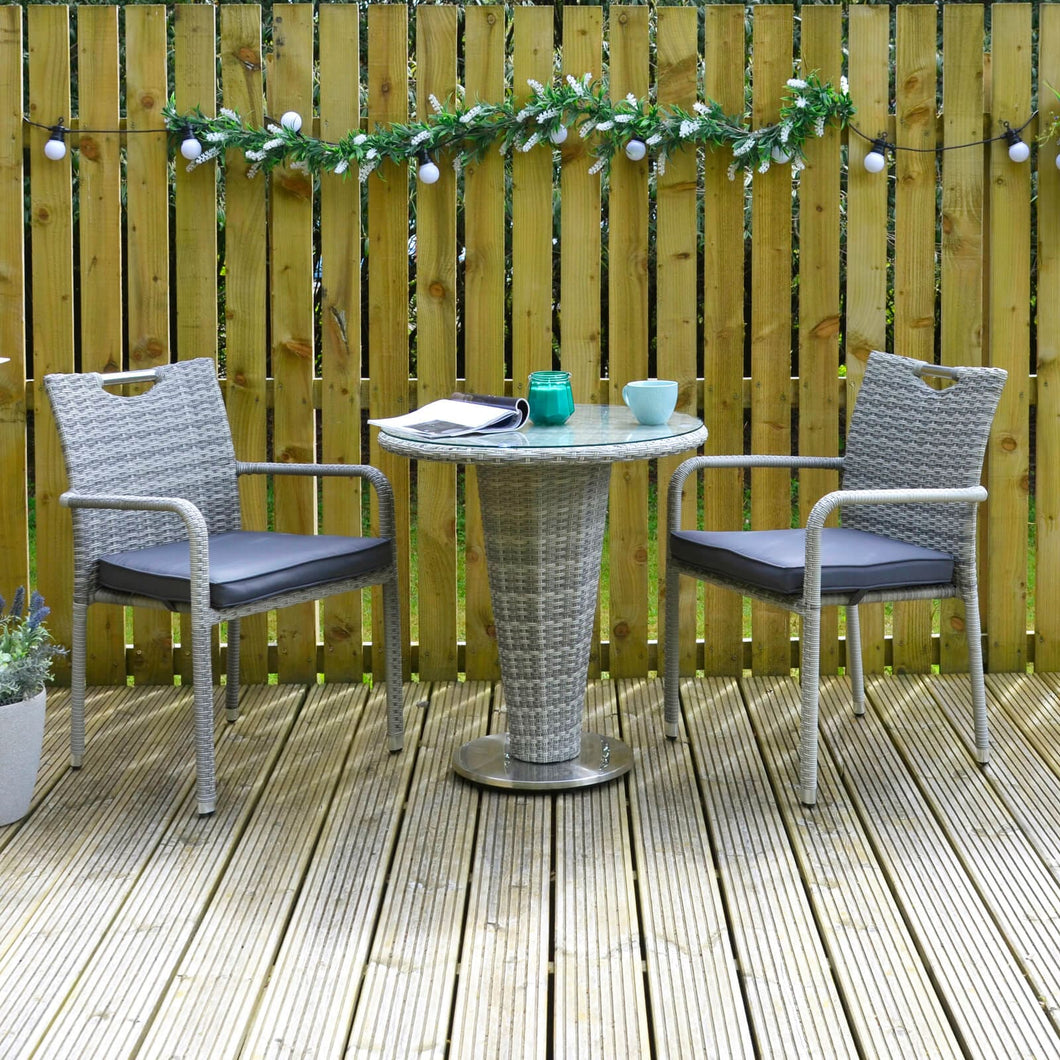 grey rattan cone bistro set on patio space with coffee mug and magazine resting on glass table top