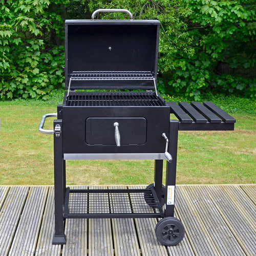 Black Rhino large bbq with lid open to show grilling and warming racks, 2 wheels, storage shelves and adjustable coal tray height, sitting on garden decking