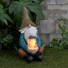 Load image into Gallery viewer, Solar power garden gnome ornament with light up jar, sitting in a garden with ivy and plants
