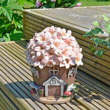 Load image into Gallery viewer, Solar Cottage with pink blossom roof sitting on decking in a garden in sunshine
