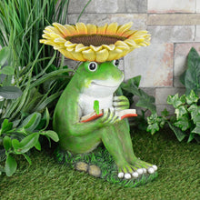Load image into Gallery viewer, Green frog design novelty bird feeder with sunflower dish top, frog reading a book with bookworm, sitting on grass in a garden with ivy and stone wall
