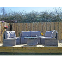 Load image into Gallery viewer, Grey rattan garden sofa set with circular coffee table and 3 sofas with side tables on decking with plants and flowers
