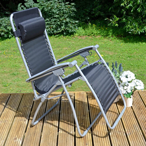 Black zero gravity garden chair, recliner with head cushion and grey frame, on decking with plants and flowers